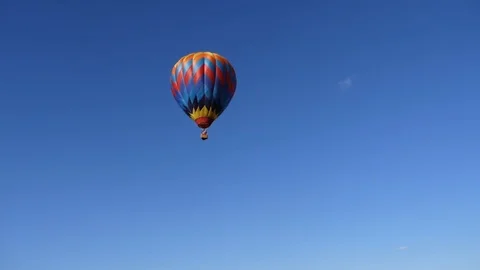 A single multi color bright hot air balloon is flying across the sky Stock Footage 95965822