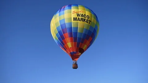 A single multi color bright hot air balloon is flying across the sky Stock Footage 95966891