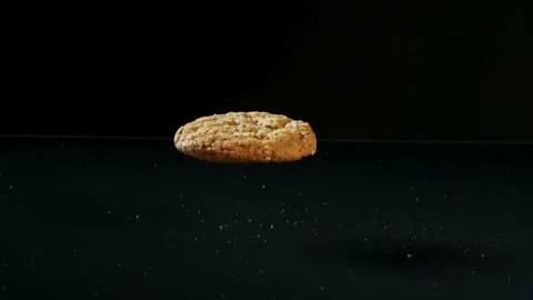 Single oatmeal cookie falling on reflective surface Stock Footage 327122707