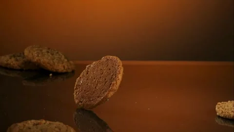 Single oatmeal cookie spinning on reflective surface Stock Footage 327122434