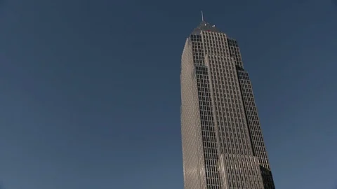 Single office building in Cleveland, OH against blue sky - Pan Down Stock Footage 89944920