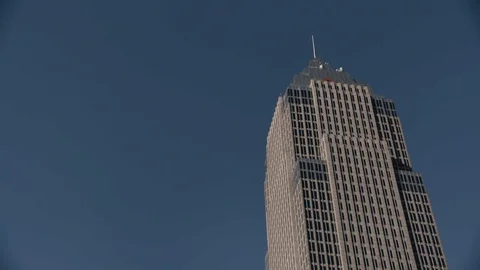 Single office building in Cleveland, OH against blue sky - Pan Across Stock Footage 89944926