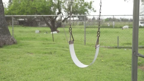 Single old childrens swing flowing in the wind Stock Footage 73583438