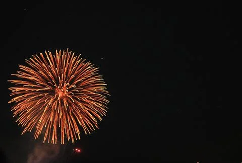 Single orange chrysanthemum firework exploding Stock Photos