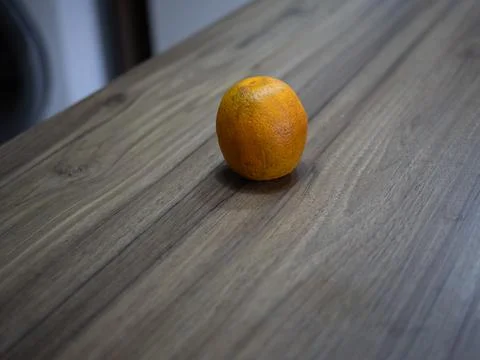 Single orange on wooden table surface Stock Photos