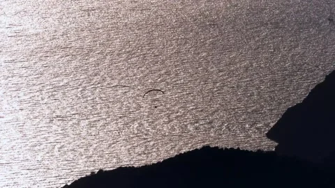 Single paraglider crosses sunset sky - Solo Paraglider and Paragliding Sunset Stock Footage 339934734