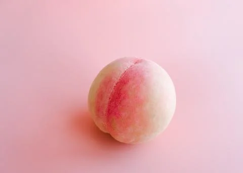 Single peach on pink background Stock Photos
