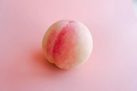Single peach on pink background Stock Photos