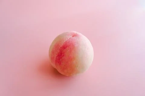 Single peach on pink background Stock Photos