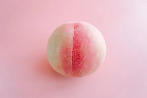Single peach on soft pink background Stock Photos