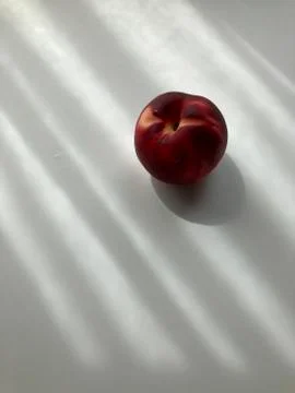 Single peach on white background with shadows Stock Photos