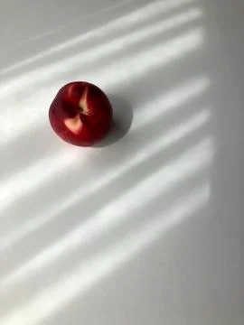 Single peach on white background with shadows Stock Photos