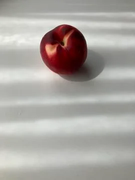 Single peach on white background with shadows Stock Photos