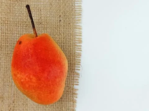 Single pear on burlap with copy space Stock Photos
