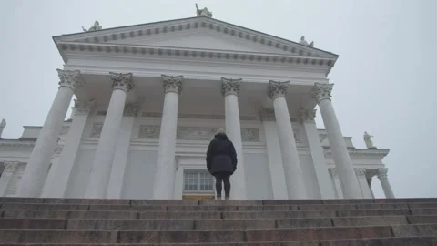 Single person standing at the top of the steps in front of Helsinki Cathedral Stock Footage 146290704