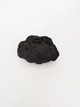 A single piece of dark, irregular coal chunk on a white background Stock Photos