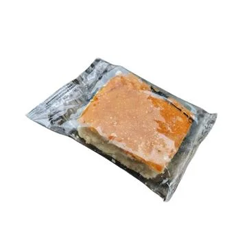 Single Piece Square Orange Glazed Sponge Cake In Transparent Plastic Packaging 스톡 사진