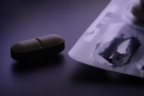 Single pill tablet next to empty blister pack Stock Photos