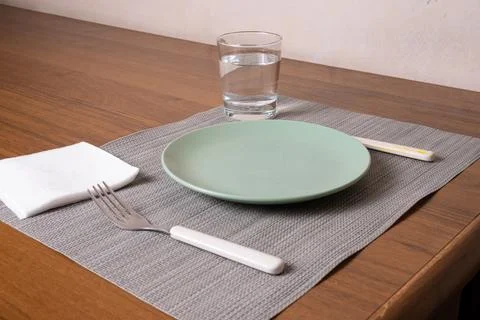 Single Place Table Setting with Plate, Water Glass and Cutlery on Wooden Tabl Stock Photos