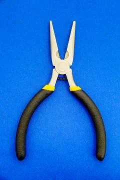 Single pliers tool with rubber handles for the master electrician on blue bac Stock Photos