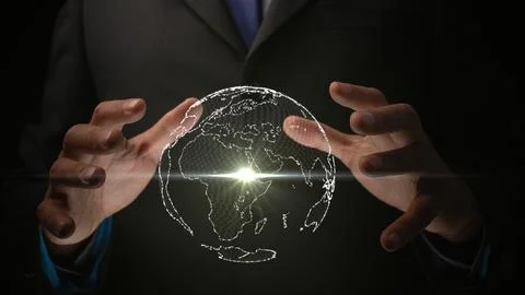 From a single point of light, a globe emerges within the illuminated hands of Stock Photos