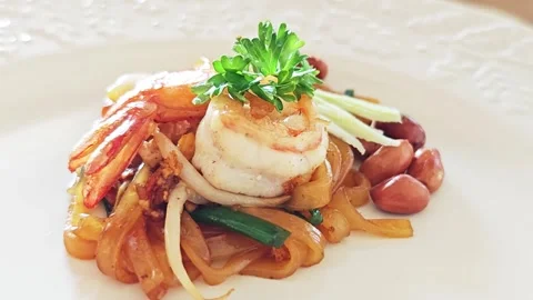 Single portion of premium Thai Pad Thai with a large shrimp on a white plate. Stock Footage 347514048