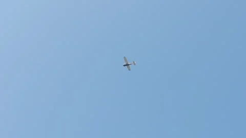Single propeller airplane flying across clear blue sky Video stock 345639152