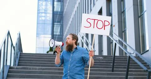 Single protest of Caucasian man with beard talking and screaming in megaphone Foto stock