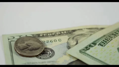 Single quarter coin lands on two twenty dollar bills Stock Footage 329595876