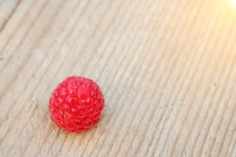 Single raspberry on wood Stock Photos