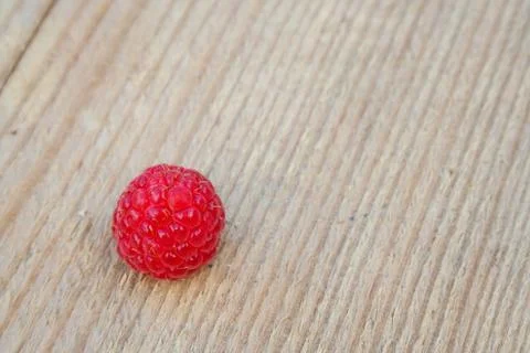 Single raspberry on wood Stock Photos