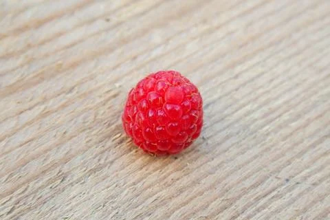 Single raspberry on wood Stock Photos