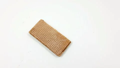 Single rectangular brown wafer cookie resting alone on a white background 스톡 동영상 329164857
