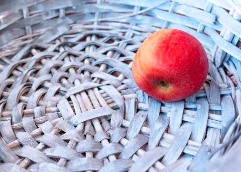 Single Red Apple in a Gray Wicker Basket. Copy Space. Foto stock