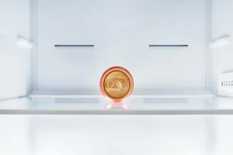 Single red beer can inside empty fridge Stock-Fotos