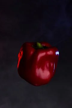 Single red bell pepper with stem isolated on black background Stock Photos
