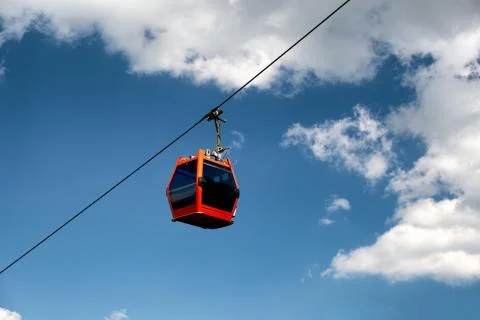 Single red cable car on cableway isolated on blue sky Stock Photos