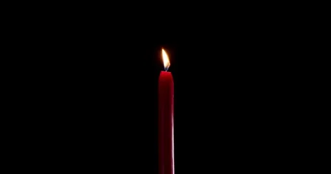 A single red candle burning on a dark, isolated background. This festive candle Stock Footage 339739907