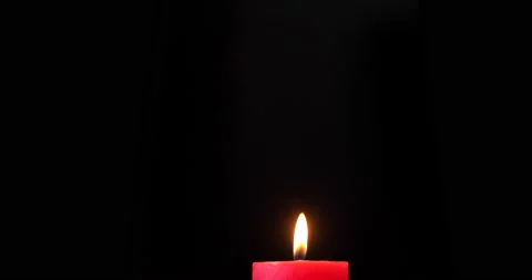 A single red candle burning. Isolated candlelight on dark background. Stock Footage 142753754
