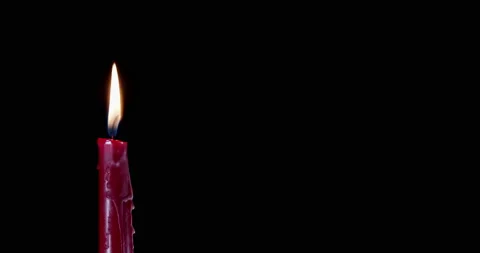 A single red candle burning. Isolated candle burning with dark background. Red Stock Footage