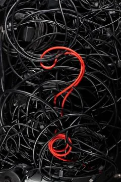 A single red cord in the form of a question mark amongst a tangle of black cords Stock Photos