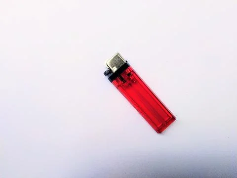 A single red disposable lighter is angled on a clean white background. Stock Photos