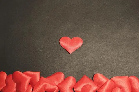 Single red heart centered in a dark background surface. Valentine's Day and Foto stock