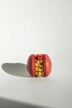 Single red macaron white background shadow vertical. A solitary red macaron.. Stock Photos