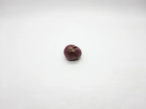 Single red onion bulb sits isolated on a plain white surface studio shot Stock Photos