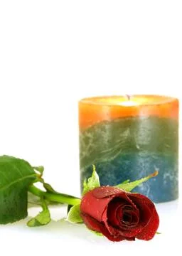 Single red rose with droplets and burning candle Stock Photos