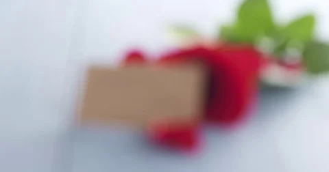 Single red rose with valentines day paper card on blue wood table focus pull Stock Footage 72220122