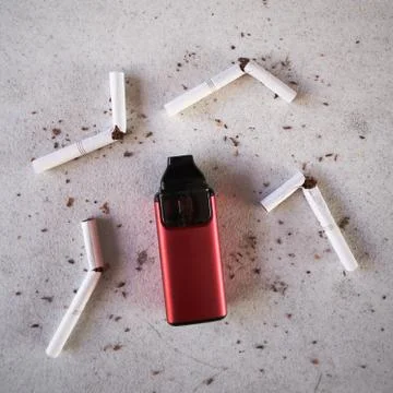 Single red vape electronic cigarette as smoking alternative with broken cigar Foto stock