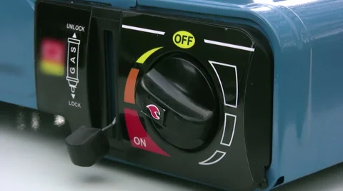 Single ring butane camping stove gas control switched on and adjusted Stock Footage 50528401