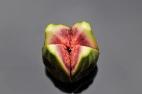 A single ripe green fig split into quarters Stock Photos